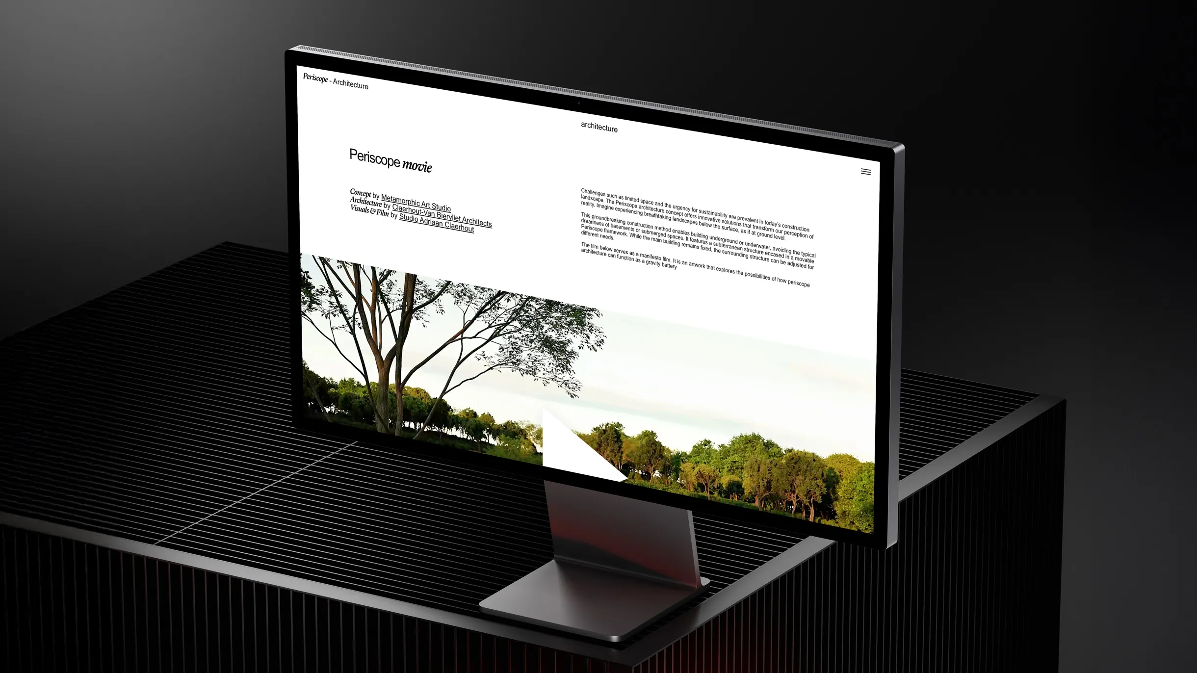 Computer monitor on a dark striped surface displaying a webpage titled 'Periscope movie' with text about architecture and a landscape image of trees.